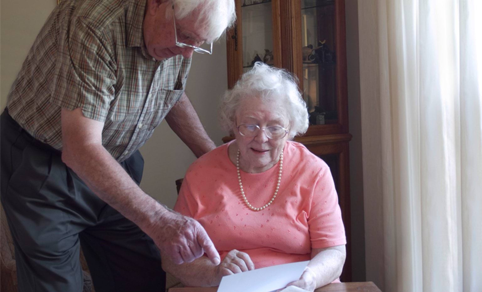 Elderly couple looking at a letter