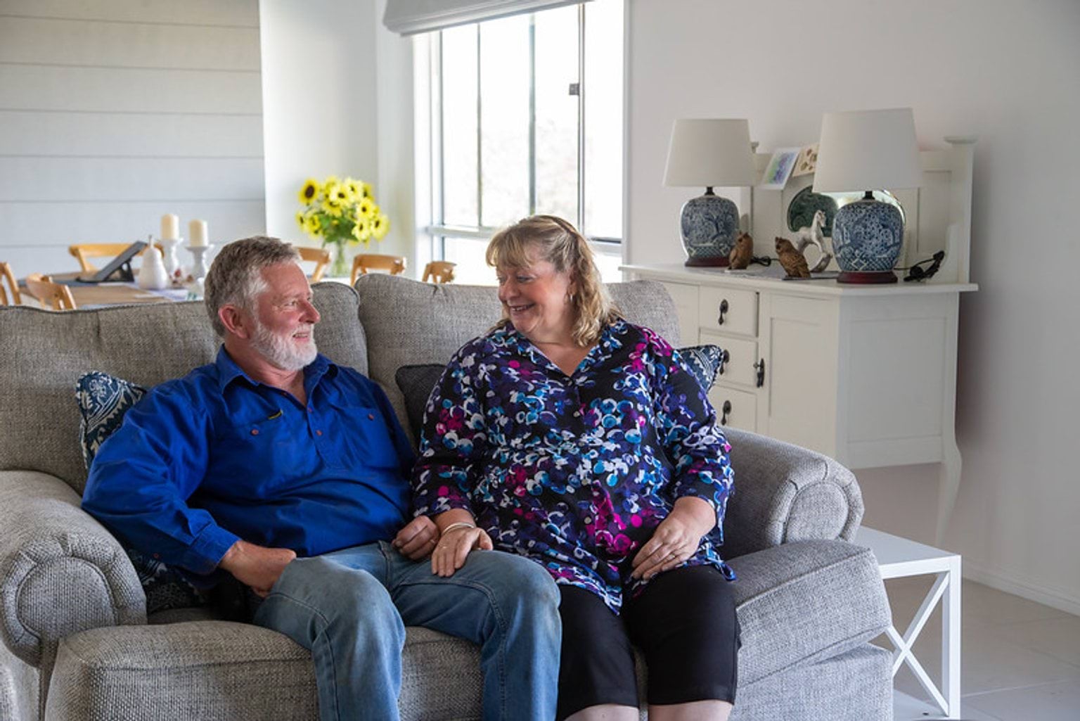 Kevin and Milusa Giles rebuild after the bushfires Kevin and Miulusa Giles sit on their couch in their home
