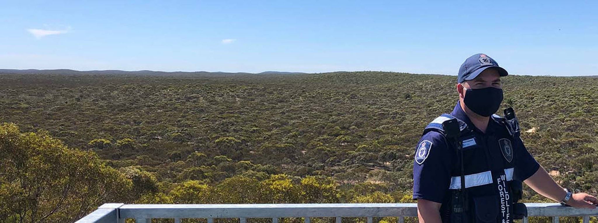 Our people and governance Image of wildlife officer standing in front of park