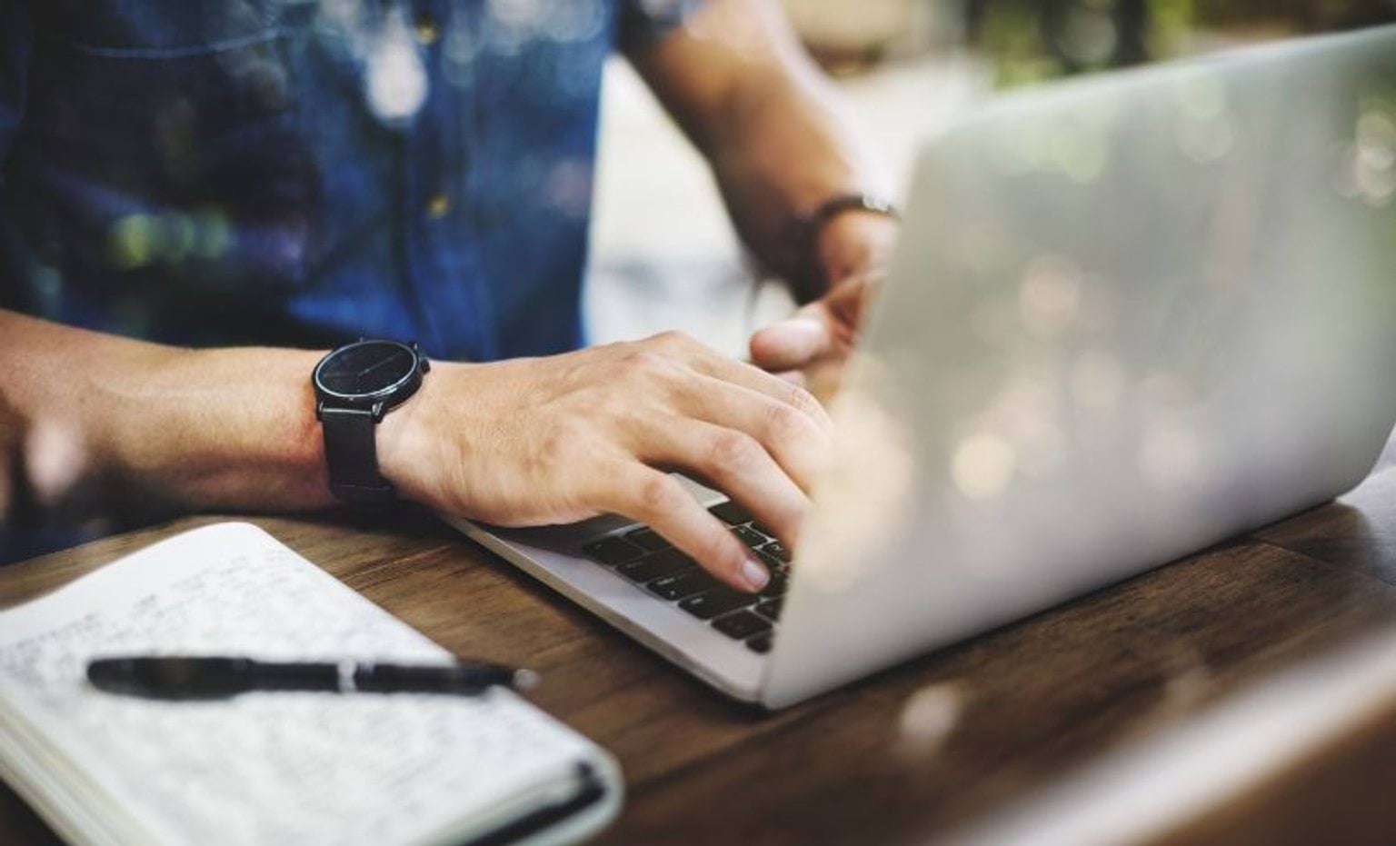 A person using a laptop on a desk A person using a laptop on a desk