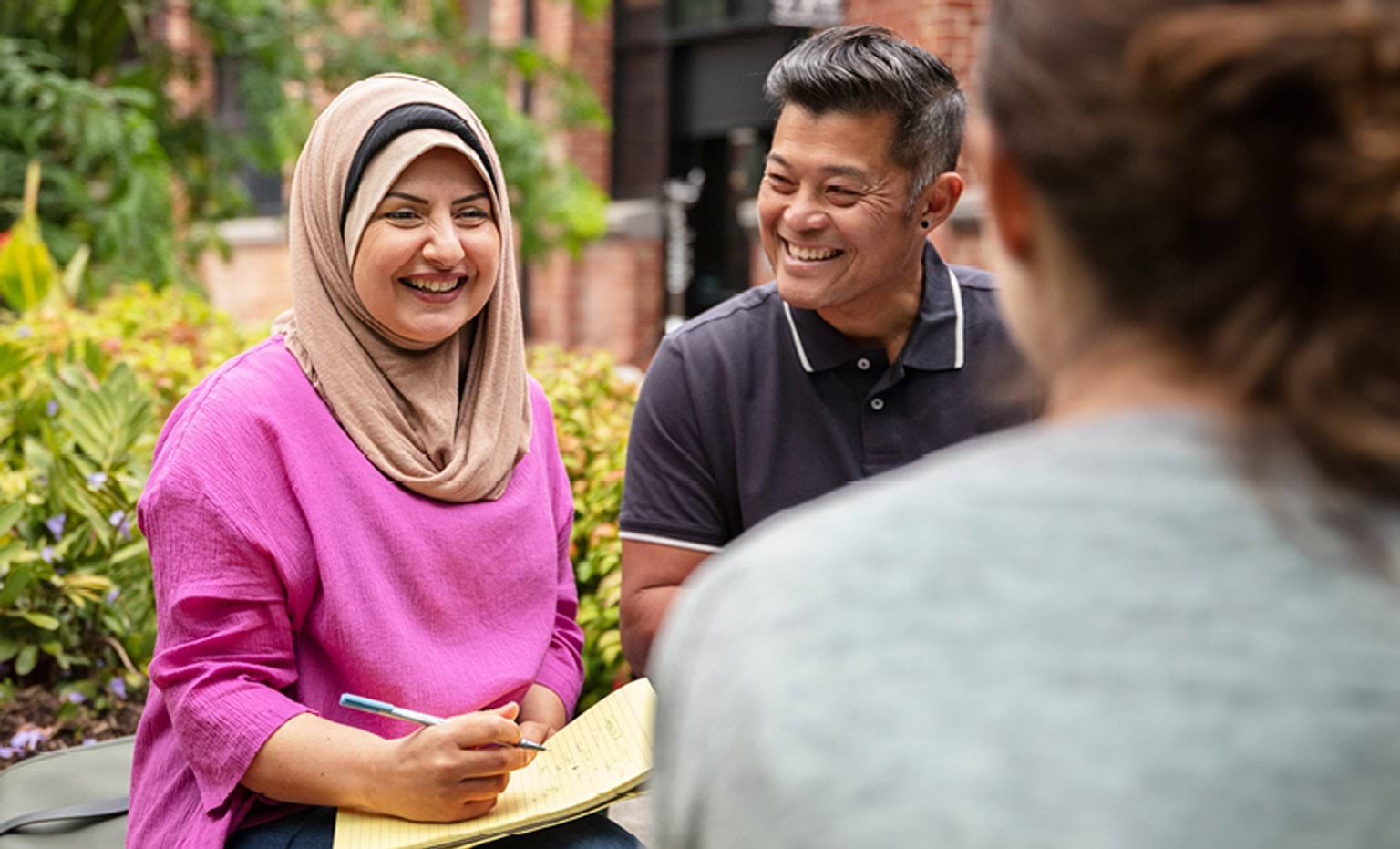 Students sitting outside and smiling