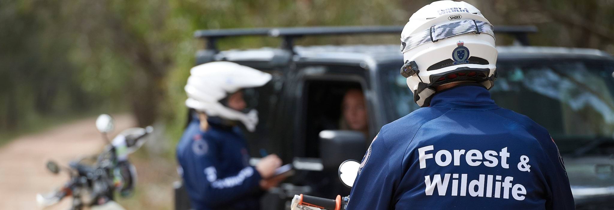 Photo of Forest and Wildlife Officers on motorbikes talking to someone in a 4WD Photo of Forest and Wildlife Officers on motorbikes talking to someone in a 4WD
