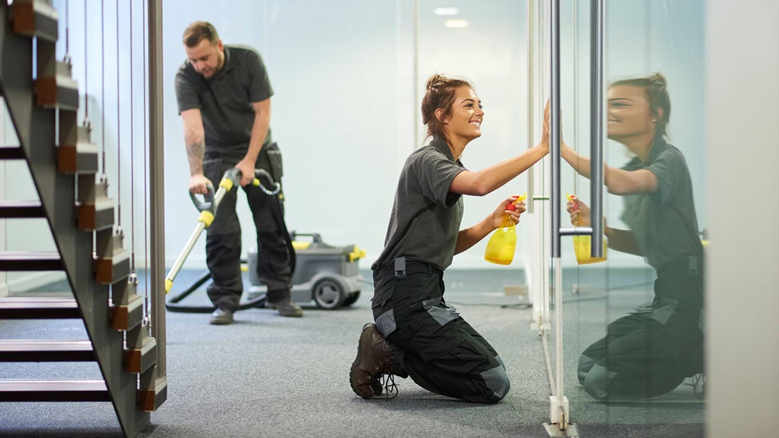 Two people cleaning office space