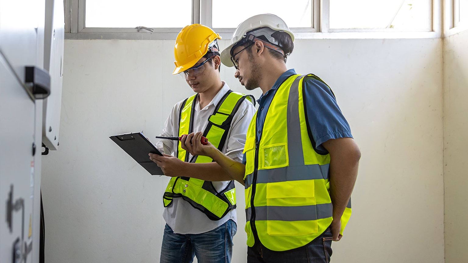 Two building inspectors talking with a clipboard