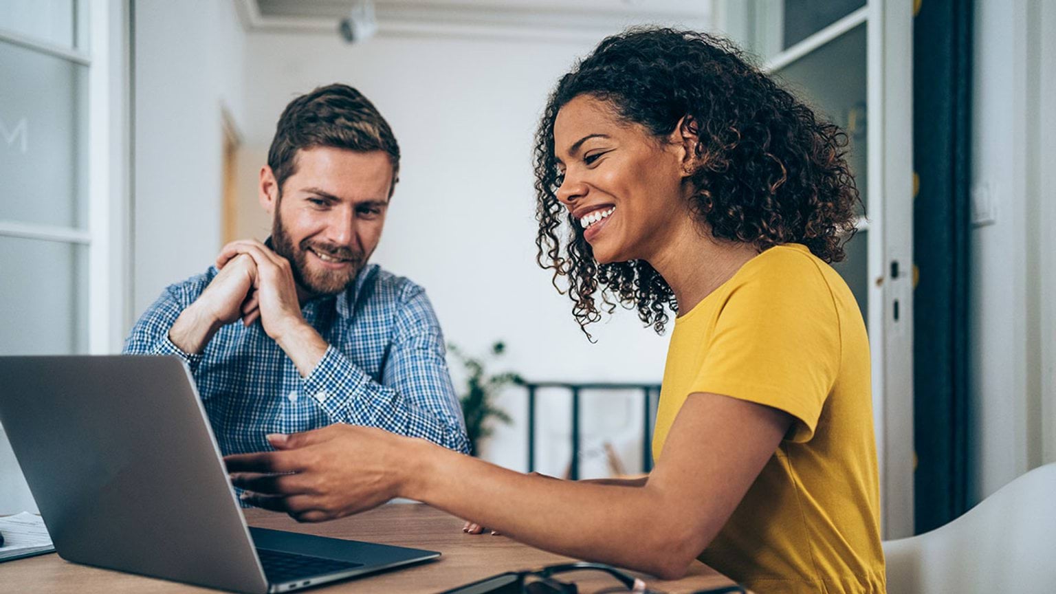 Two people working together on a laptop