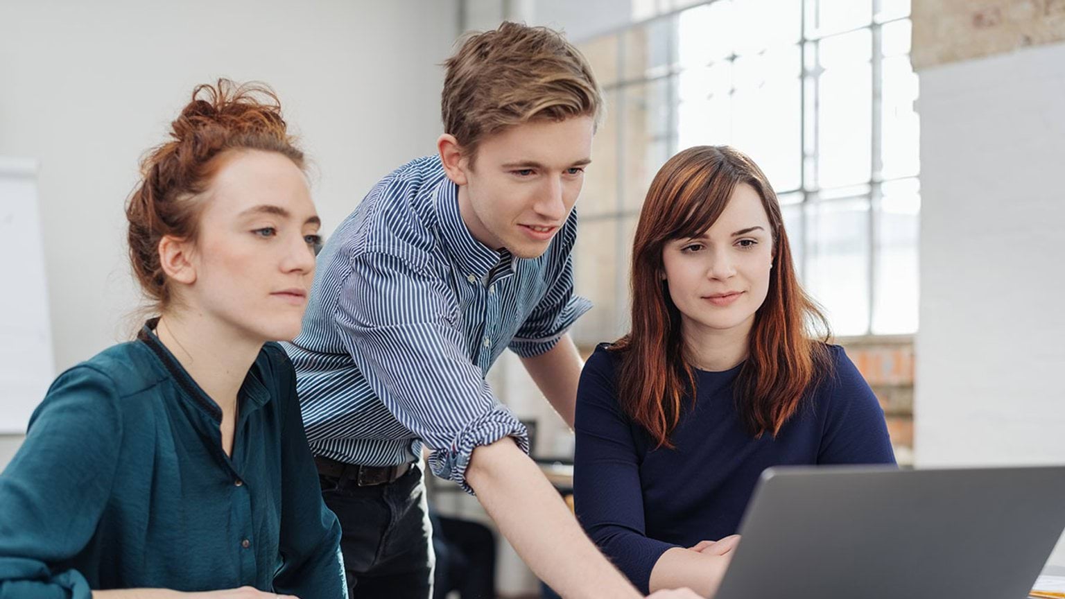 Group of people looking into laptop