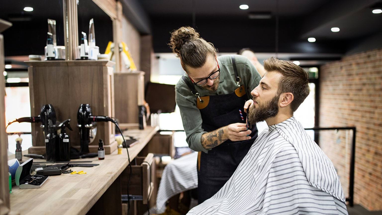 Barer giving a beard trim to client