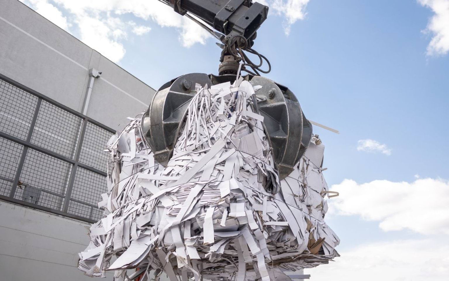Paper and cardboard recycling A crane picking up a bale of paper and cardboard for recycling