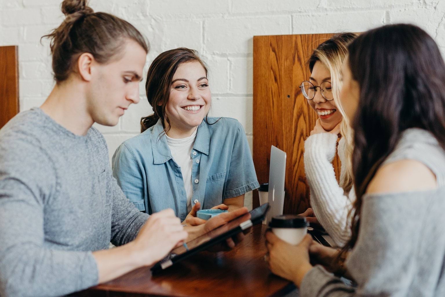Four people sitting at a table smiling.