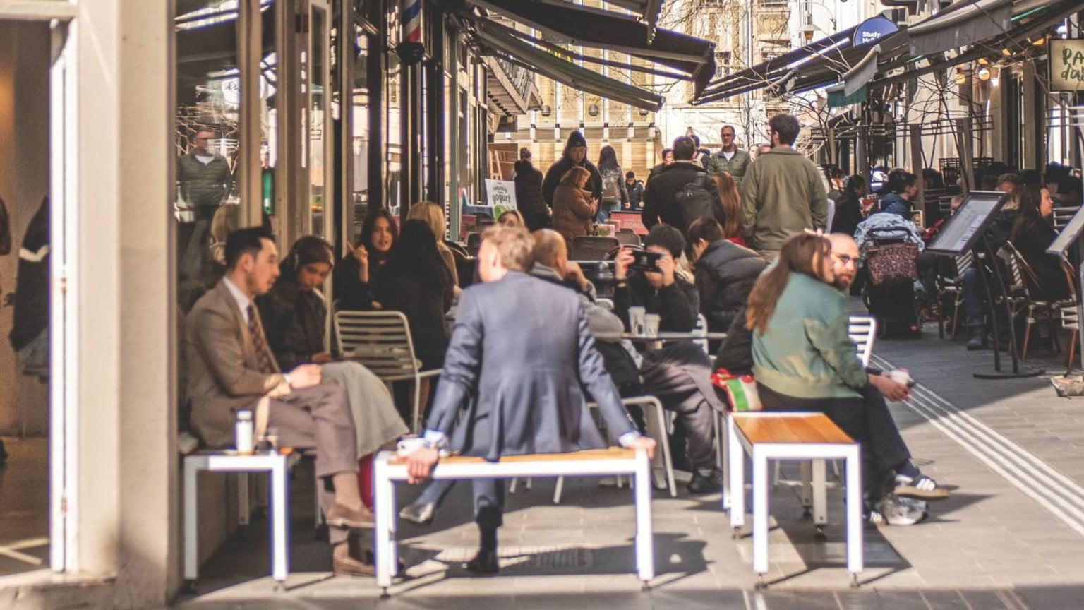 Group of people sitting outside at a busy cafe Group of people sitting outside at a busy cafe