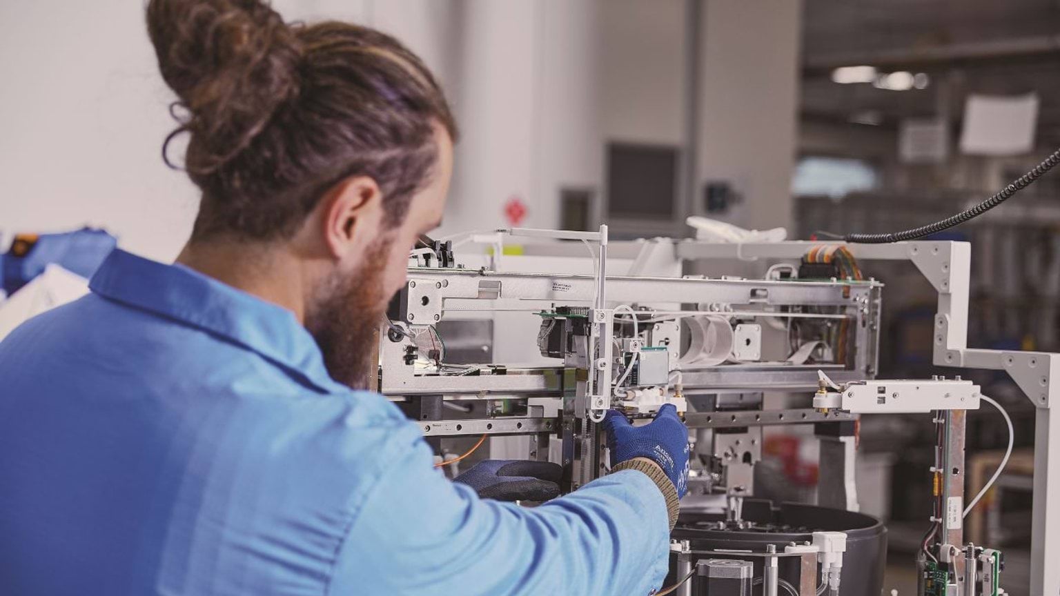 Person working with advanced medical equipment in a lab Person working with advanced medical equipment in a lab
