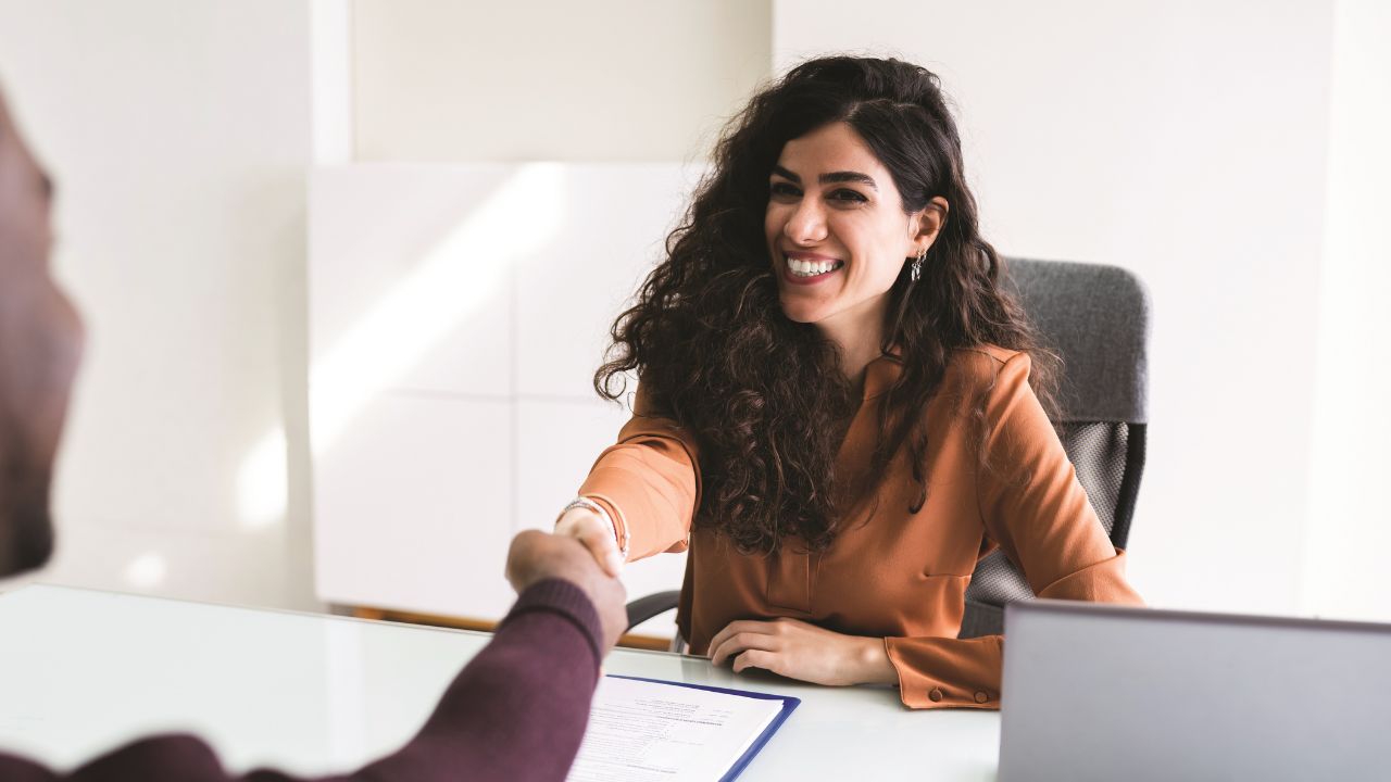 Two people shaking hands in a meeting room Two people shaking hands in a meeting room