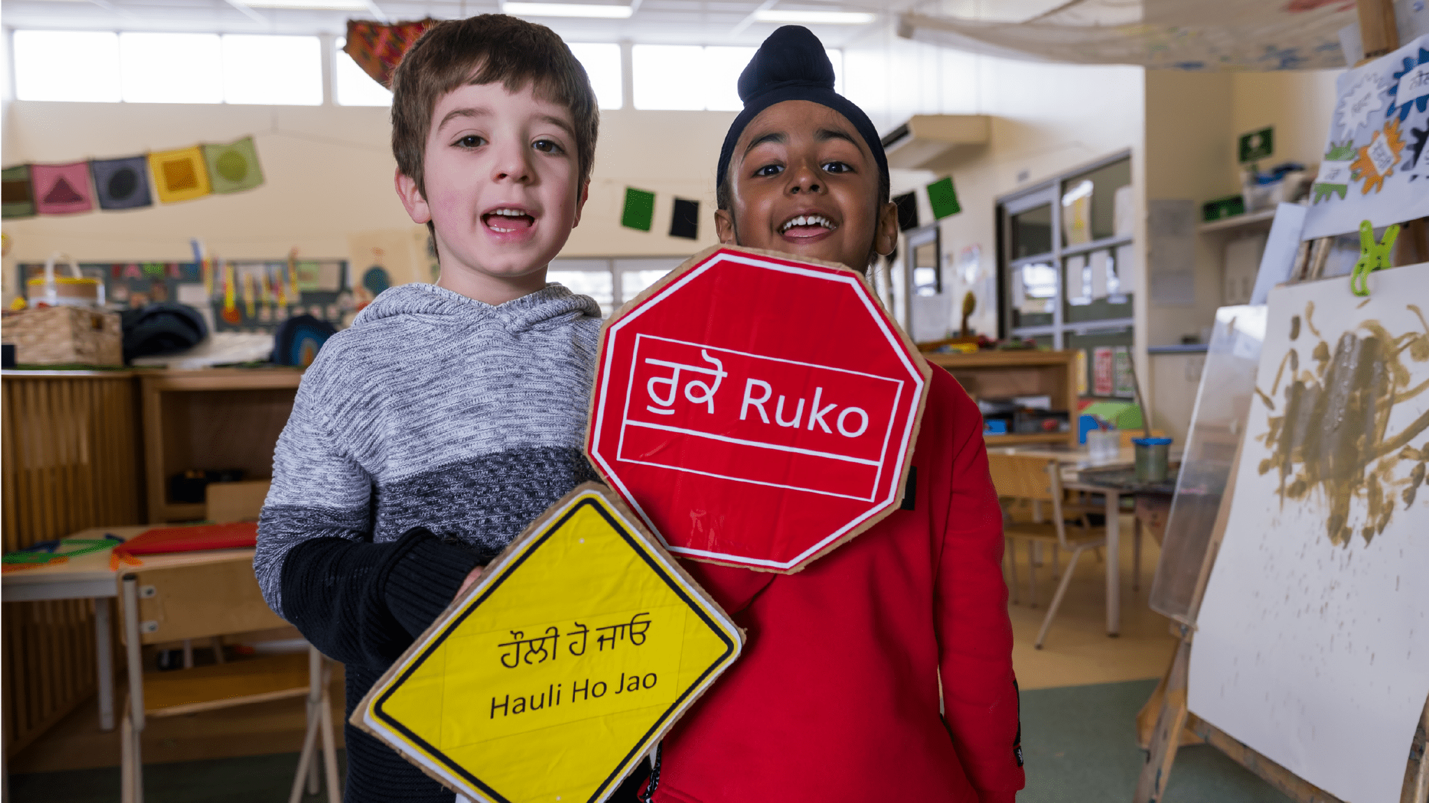 Children hold road signs in their languages
