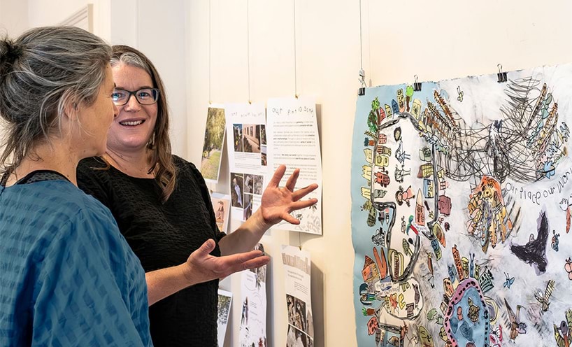 Two women looking at an exhibit at 'Our Place Our World exhibition'