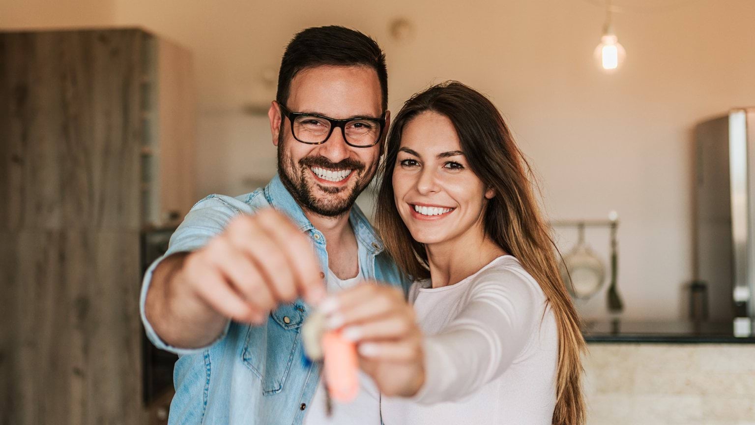 A man and a woman holding a key and smiling