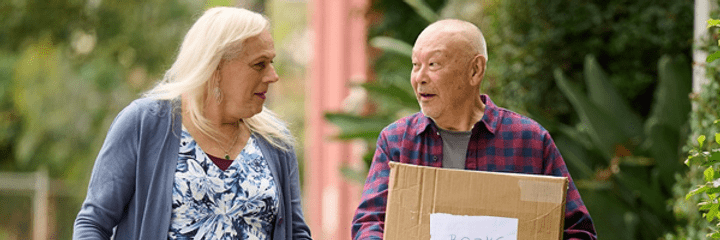 A man carrying a moving box for a trans woman