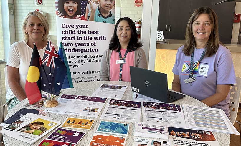3 professionals sitting around a table laid out with resources