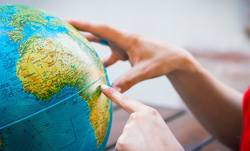 Hands exploring a globe