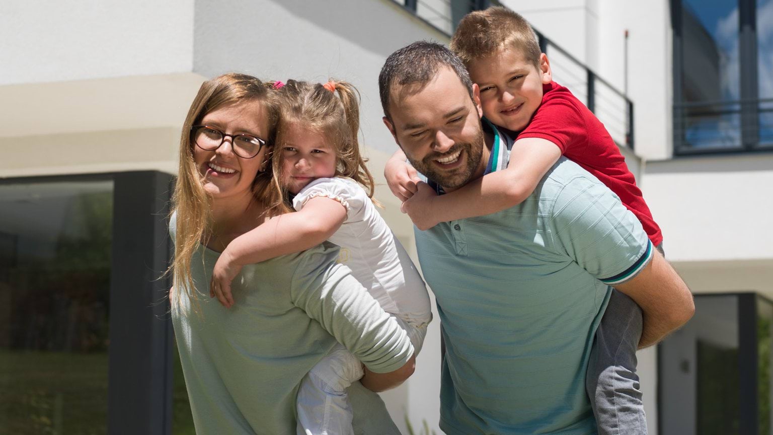 Family picture with children on the backs of their parents.