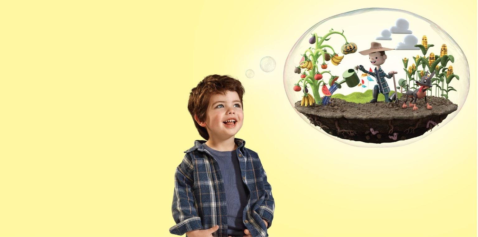 A smiling young boy looks up at a thought bubble showing a colourful garden scene. Inside the bubble, a cheerful cartoon gardener waters plants while a worm peeks from the soil and vegetables grow all around. The background is soft yellow.