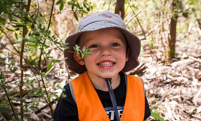 A child with a sun hat on, smiling