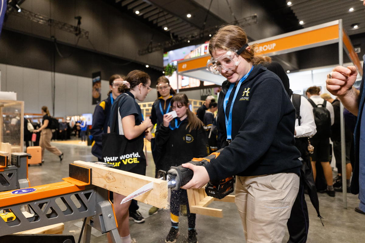 Female student cutting wood with saw