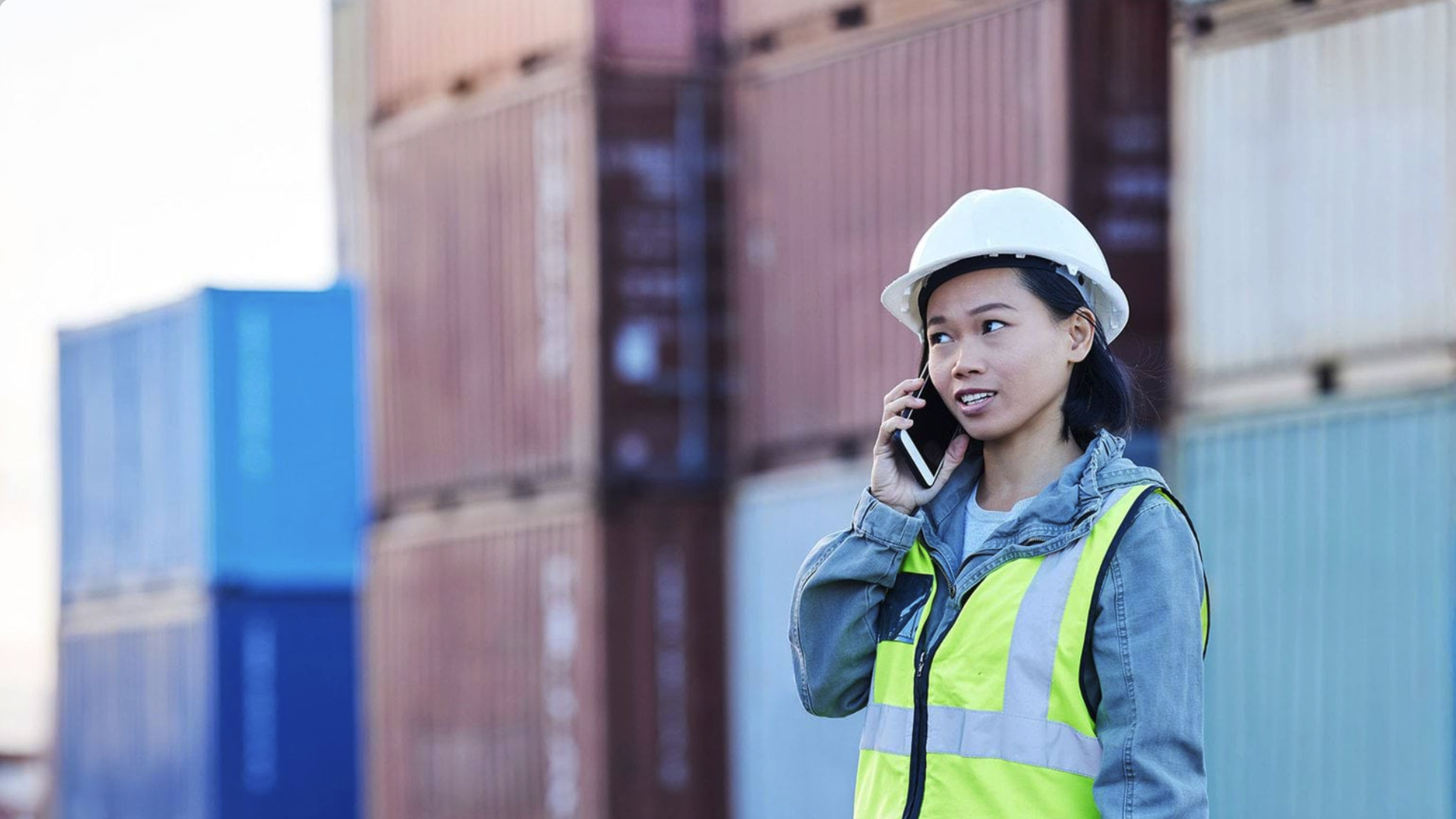 Woman in high-vis work gear on mobile phone