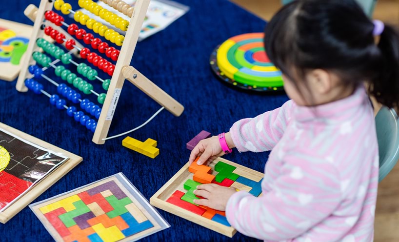 A child playing with colourful block puzzles.
